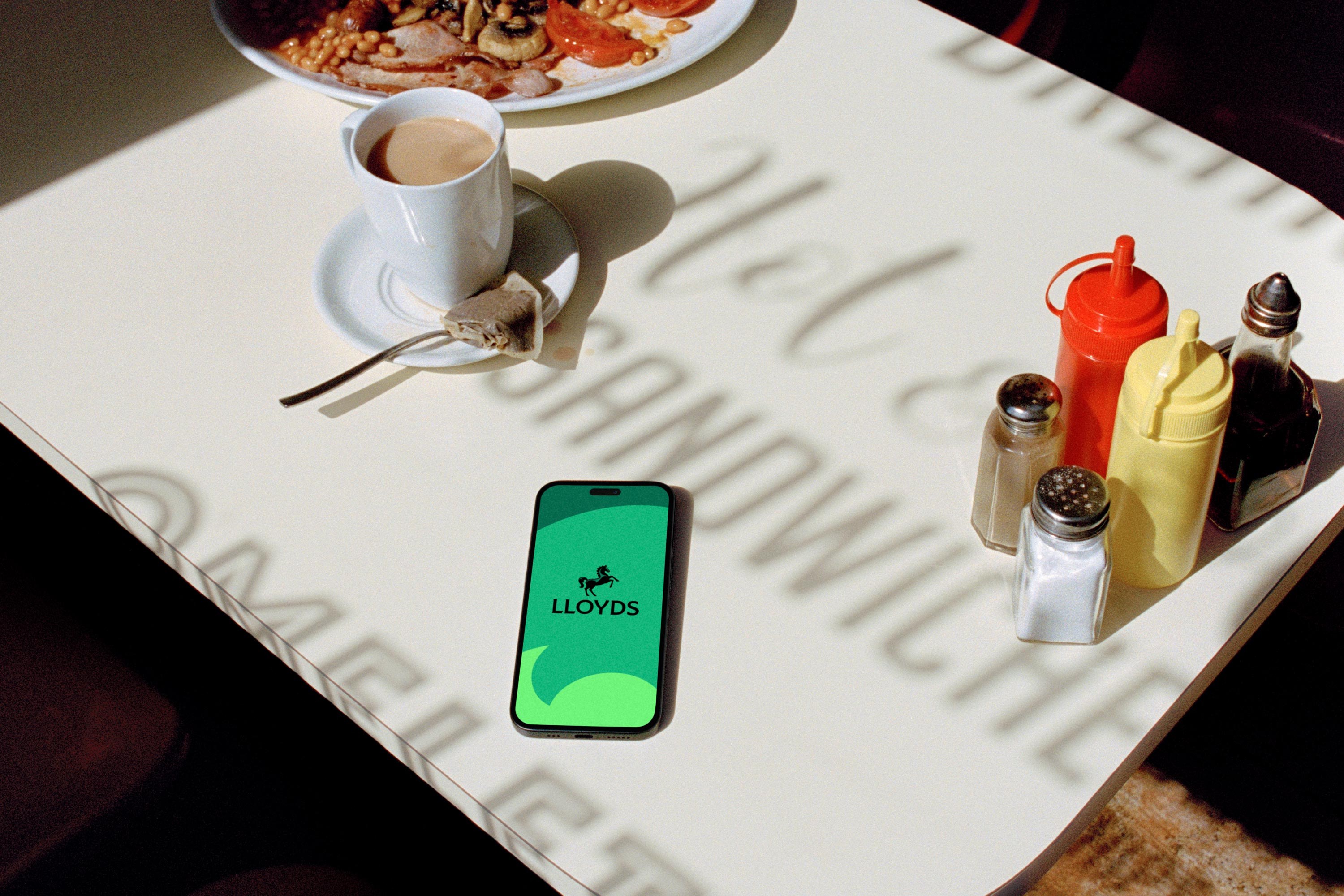 Lloyds rebrand: phone with the horse logo on a cafe table