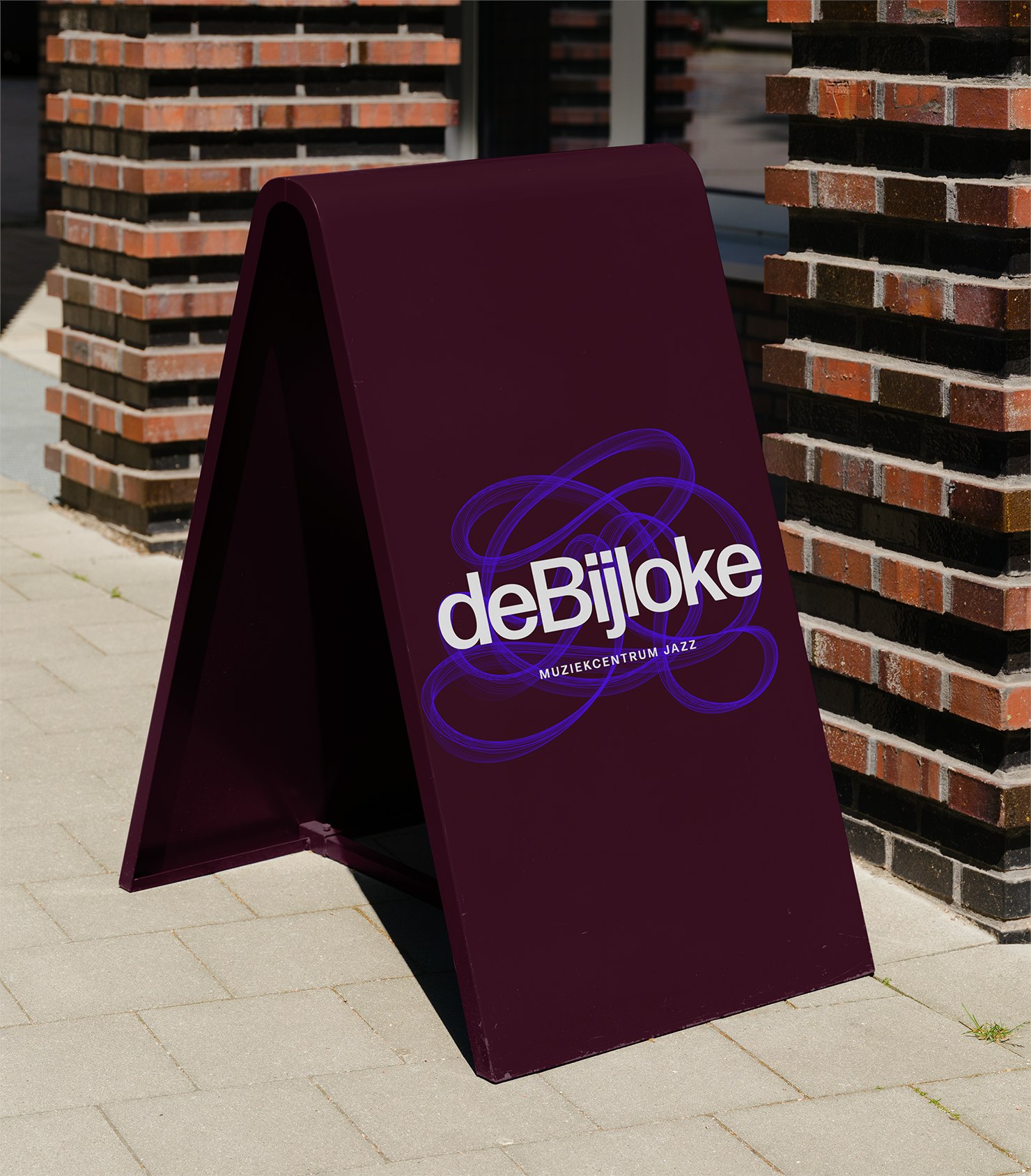 De Bijloke Jazz pavement signage in white and violet on maroon