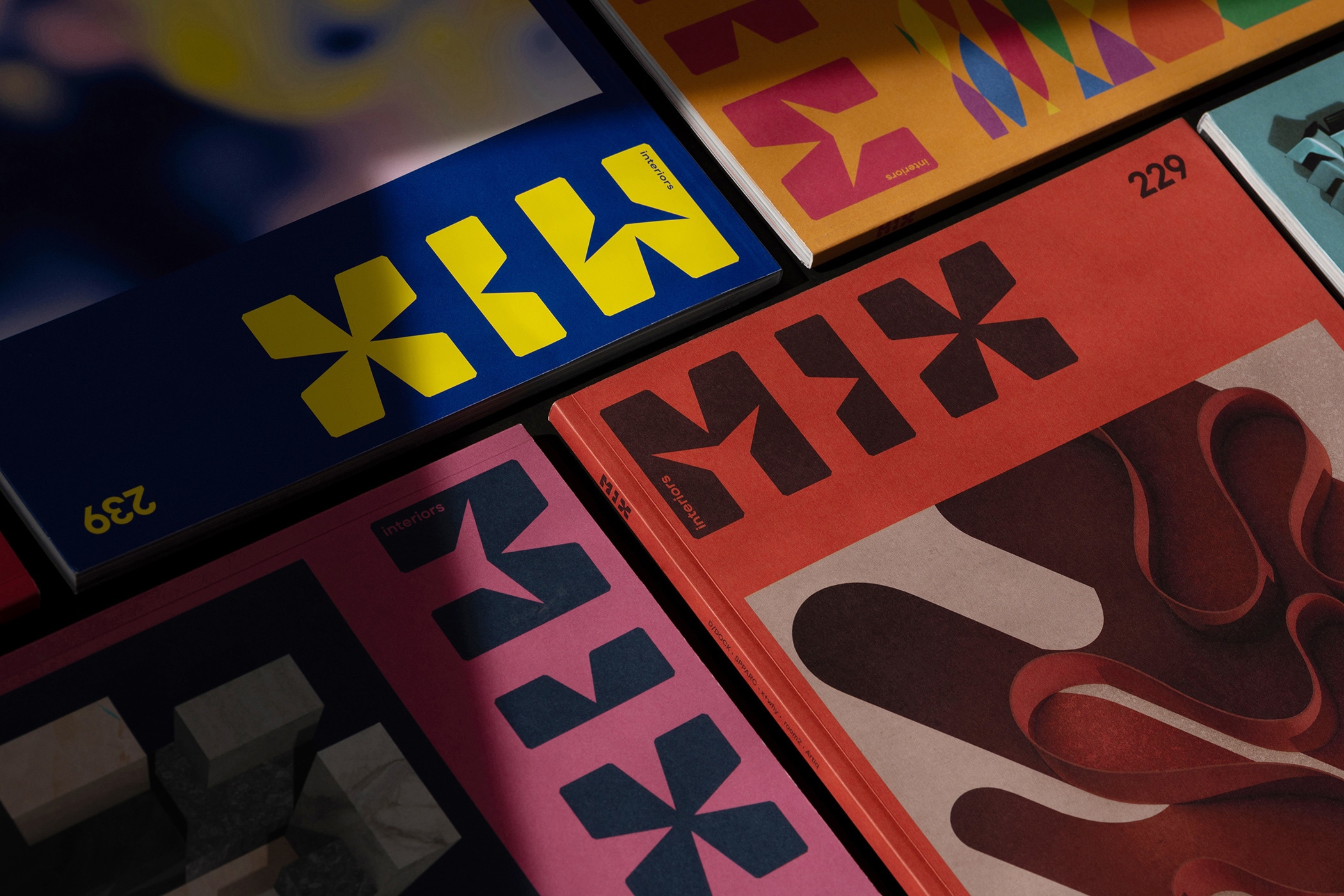 Overlapping Mix Interiors magazine covers with the MIX logo in bold two-tone colourways