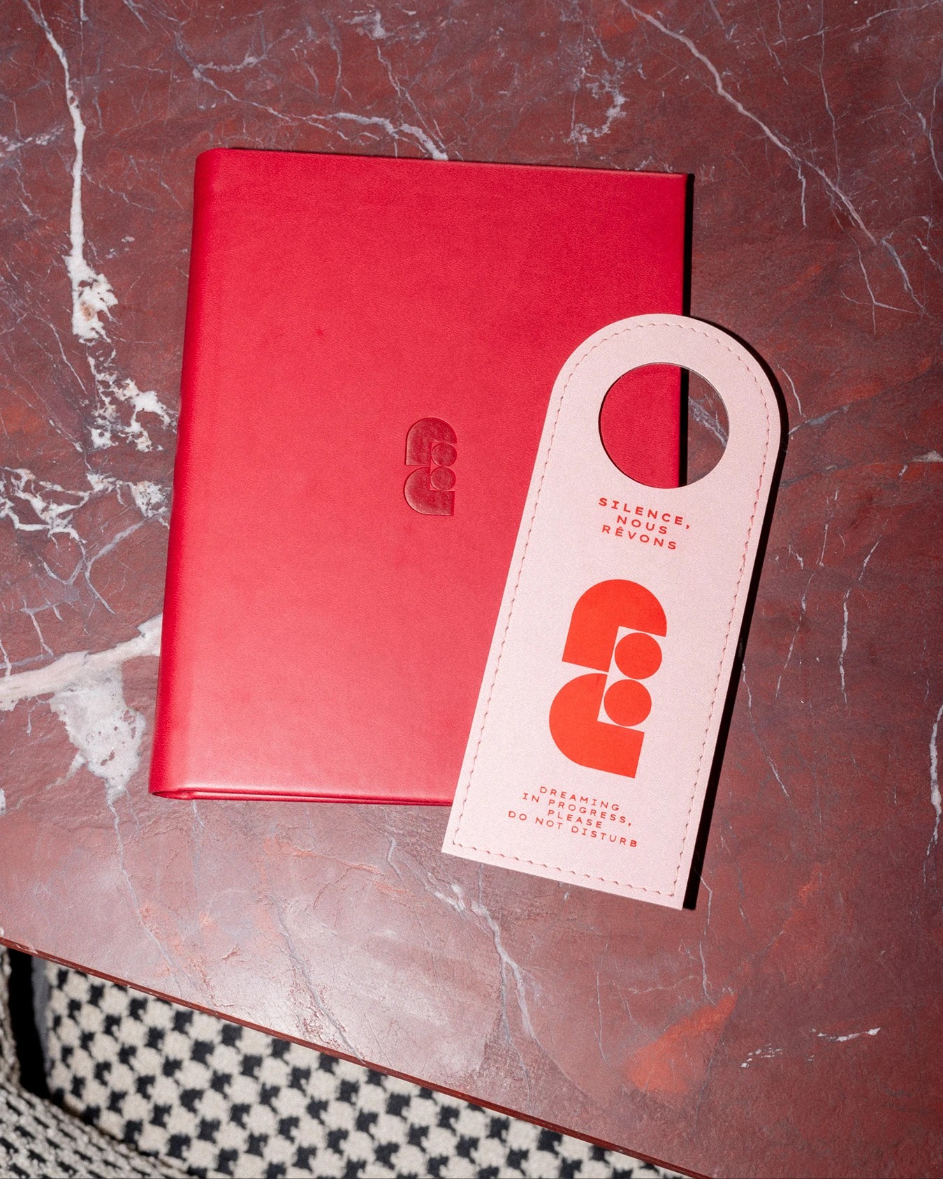 Faubourg Galant branding red leather book and stitched do not disturb door hanger