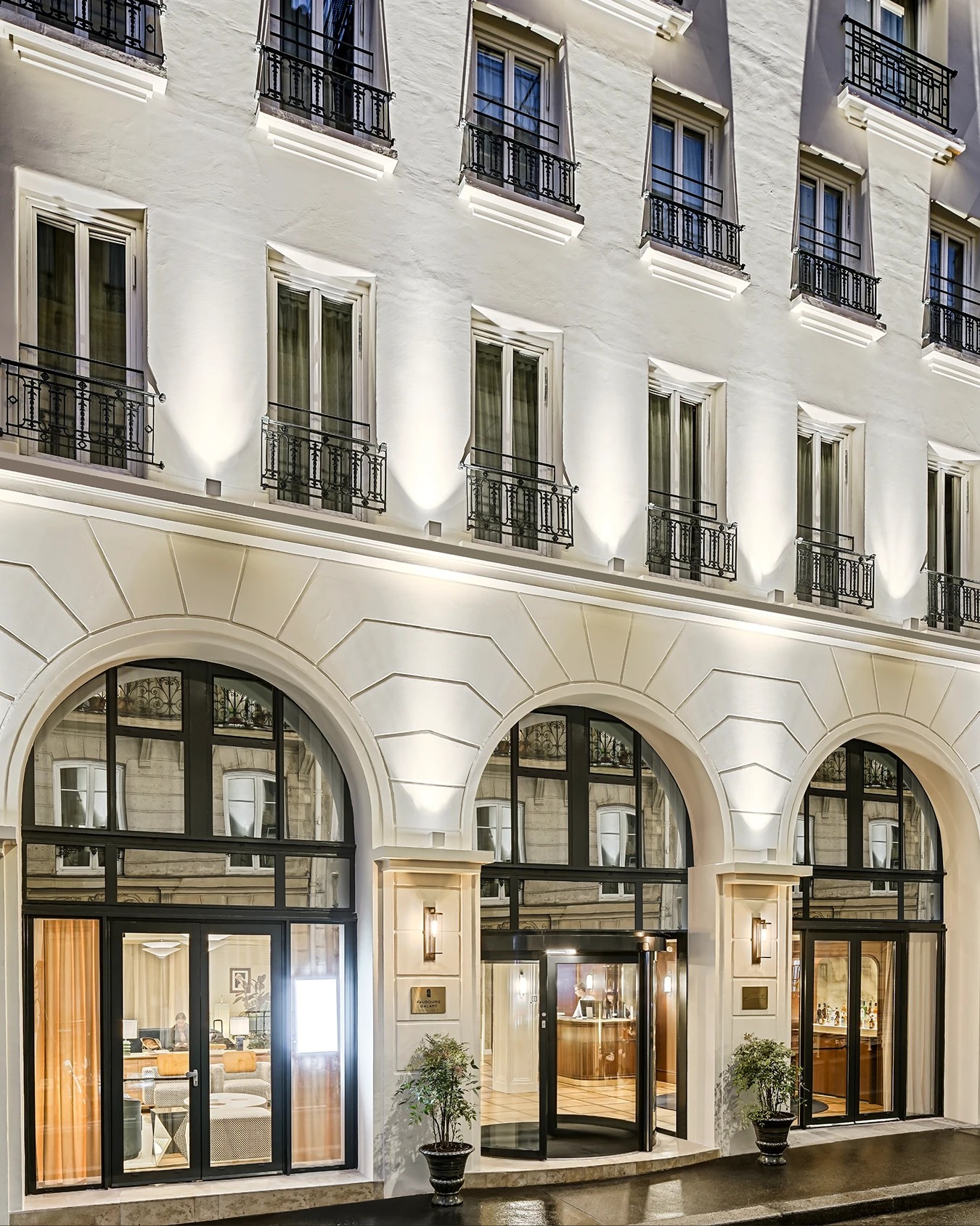 Faubourg Galant branding classical Parisian hotel facade with illuminated arches