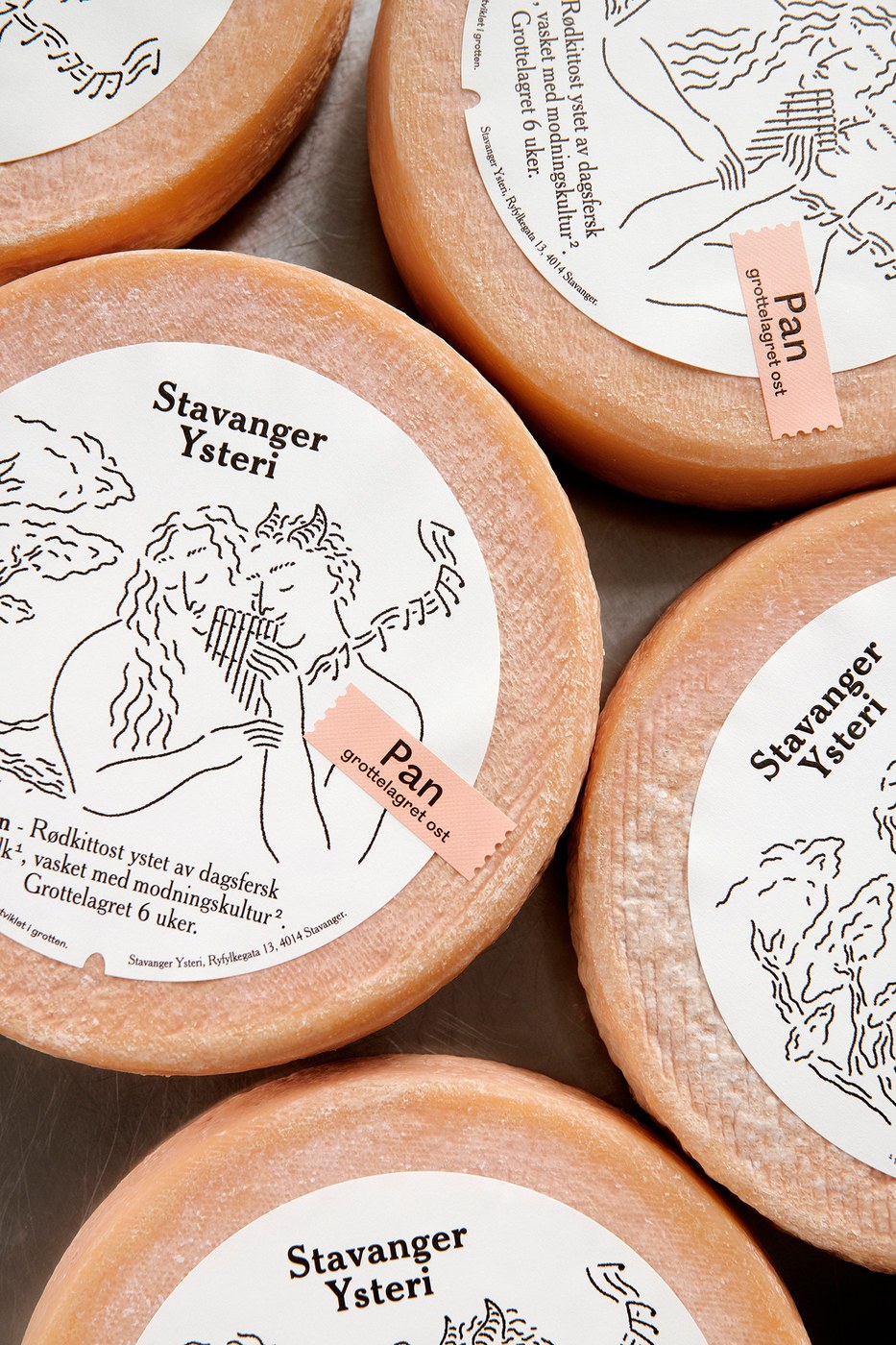 Tactile macro detail of round cheese labels showcasing circular embossing and Stavanger Ysteri wordmark