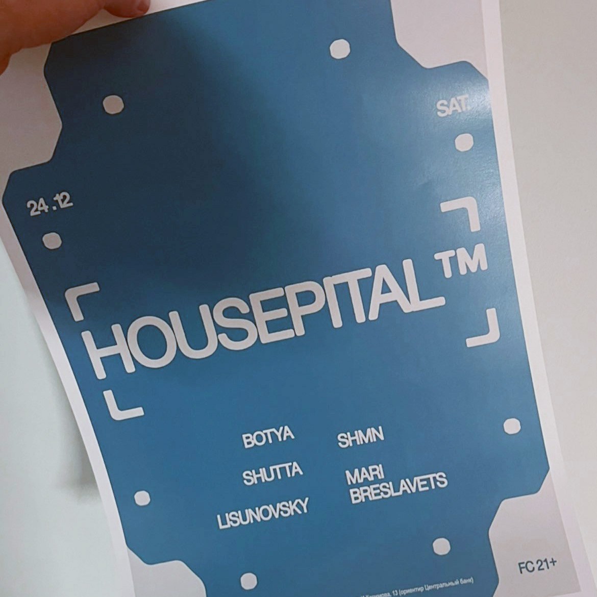 Physical die-cut event spec card and VIP pass held in hand showing tactile paper grain and branding details