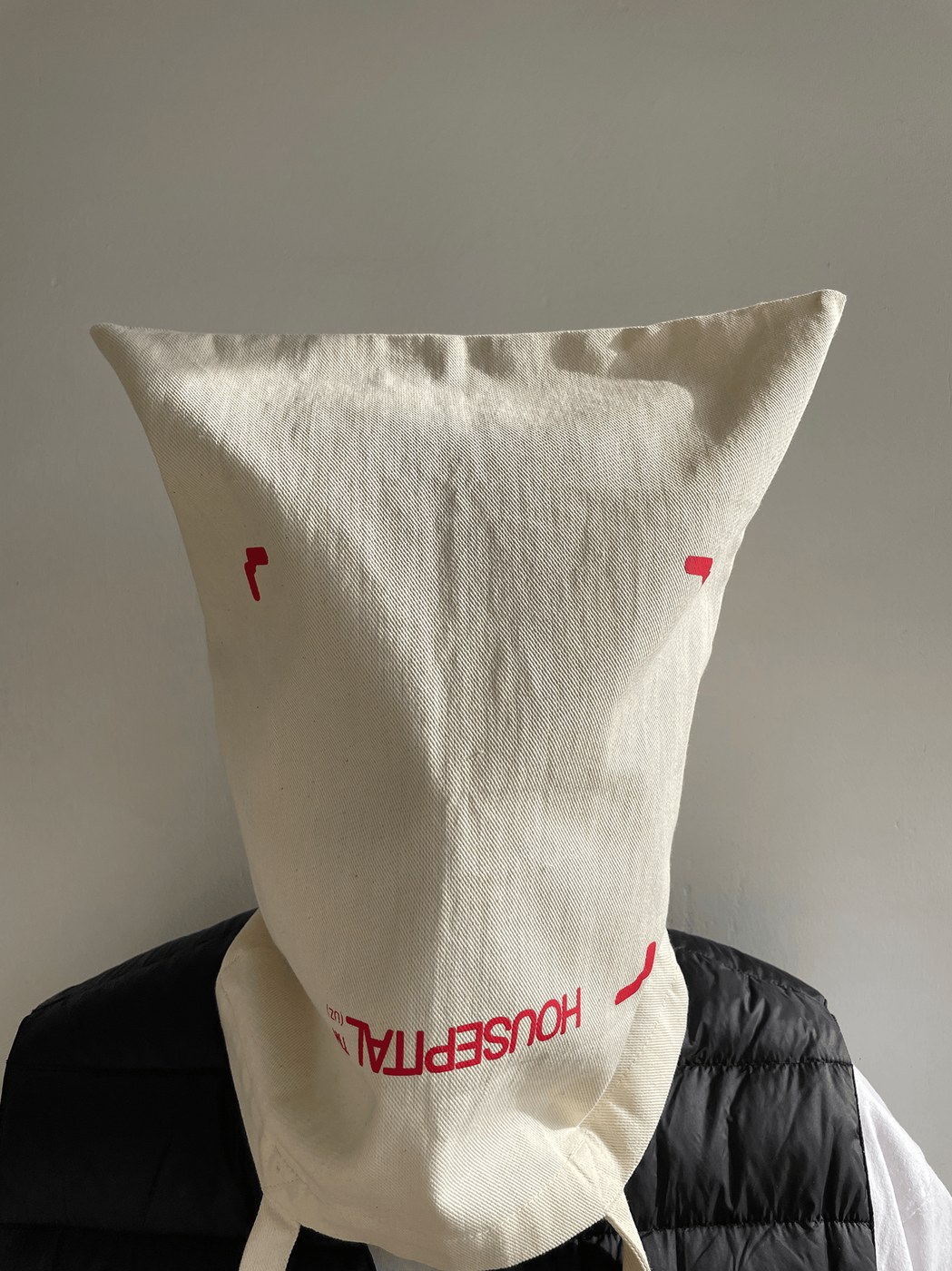 Raw unbleached cotton canvas tote bag with red crop marks and inverted Housepital branding typography