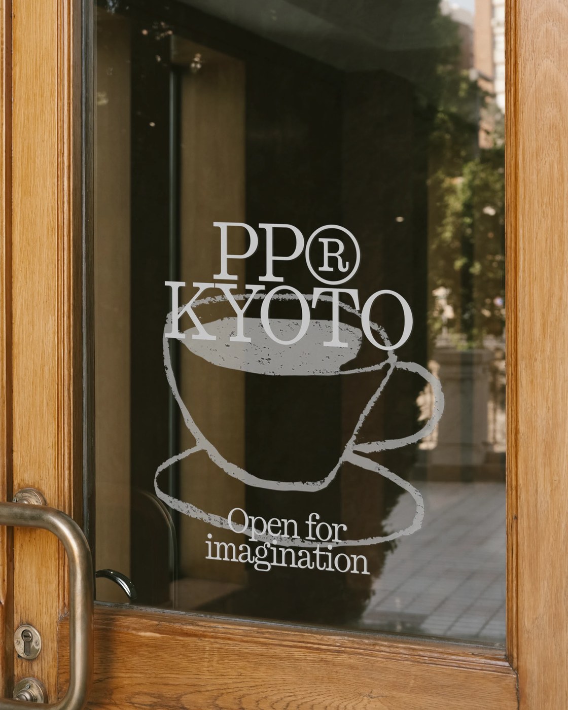 PP Kyoto logo wordmark decal on wooden glass entrance door demonstrating typeface design