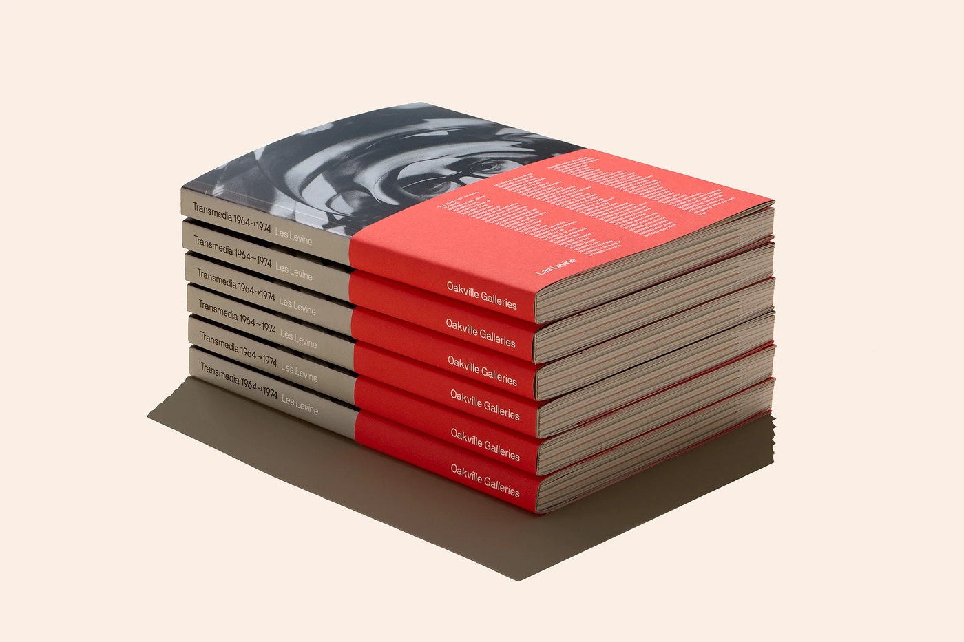 Tactile exhibition catalogue stack featuring red bellyband wraps and spine typography in editorial design by Underline Studio