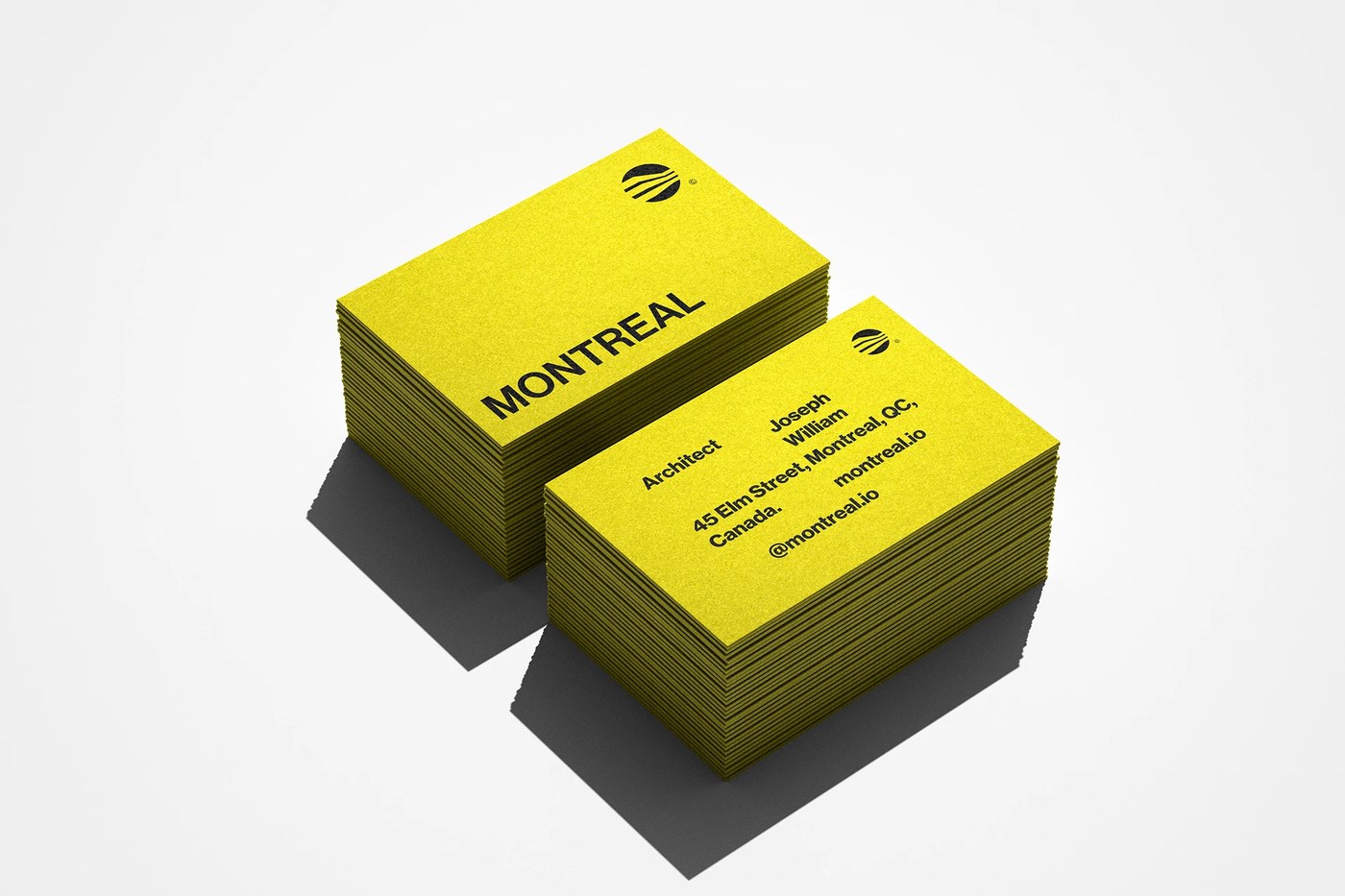 Textured yellow business card stacks in the Montreal Architecture brand identity system
