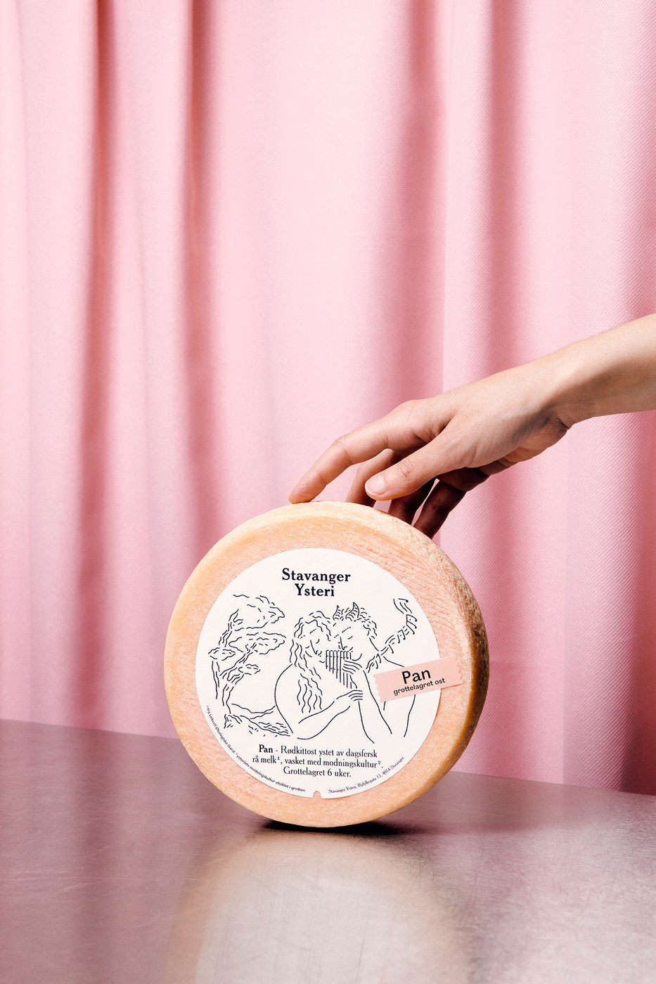 Artisan Pan cheese wheel presented upright with circular label and pastel pink debossed name tag in packaging design by OlssønBarbieri