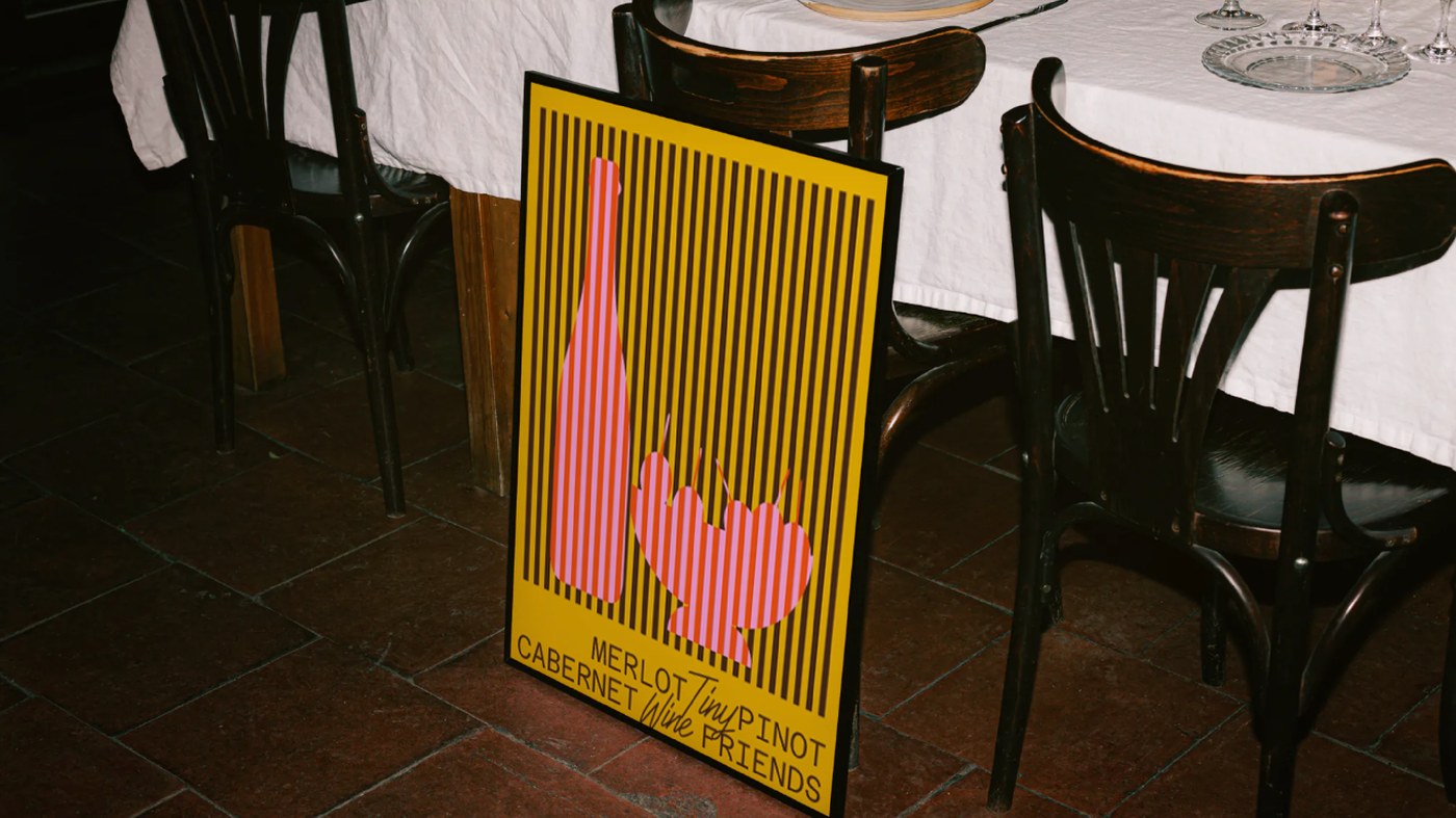 Framed yellow bistro poster with striped bottle illustration and wine varietal branding typography